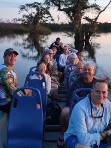 Conservation travelers smiling and enjoying an evening on the water in the Ecuadorian Amazon